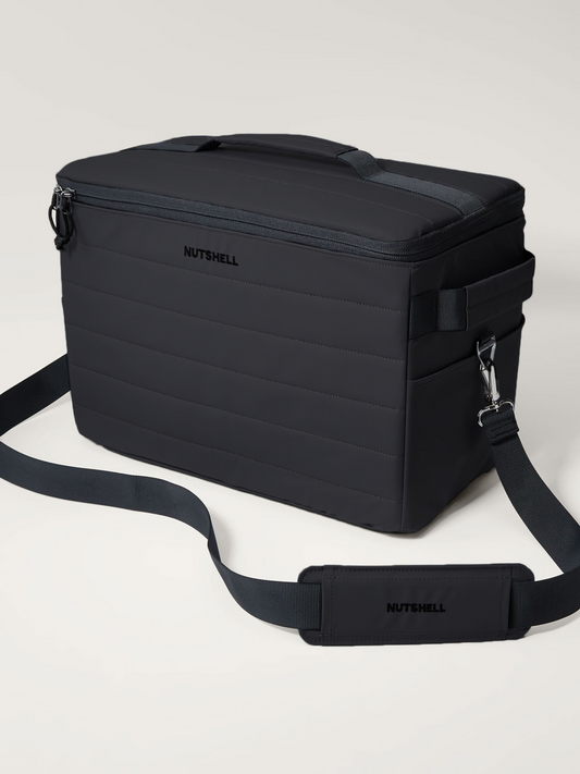 Black cooler bag with a shoulder strap on a light gray background